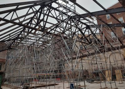 extensive impressive view of scaffolding under open-air roofing beams